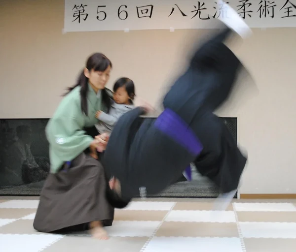 Une femme portant un enfant montre une technique de self-defense